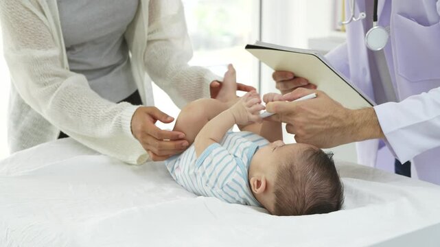 Asian loving mother comforts her three-month-old, as a male doctor administers essential childhood vaccinations, ensuring the baby's healthy future in a calm, professional setting.