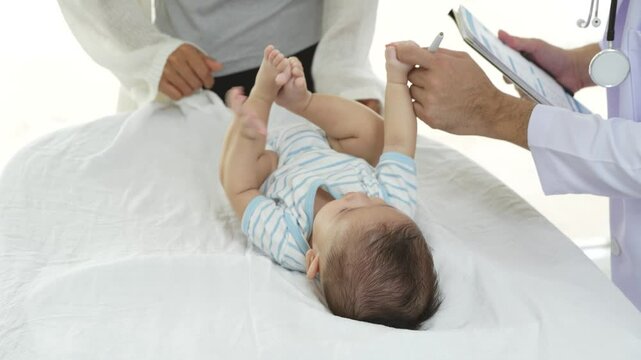 Asian loving mother comforts her three-month-old, as a male doctor administers essential childhood vaccinations, ensuring the baby's healthy future in a calm, professional setting.