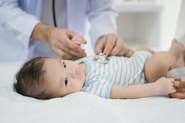 A male doctor meticulously examines a three-month-old infant, conducting a thorough health checkup...