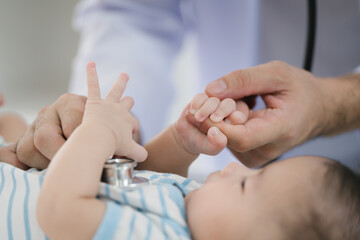 A male doctor meticulously examines a three-month-old infant, conducting a thorough health checkup...