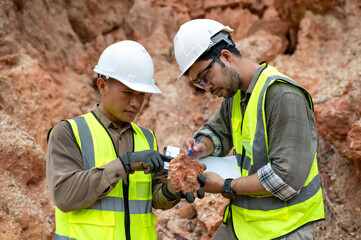 Geologists pick up rocks to analyze the minerals in the soil