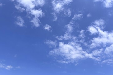 Fototapeta premium Azure canvas adorned with scattered clouds
