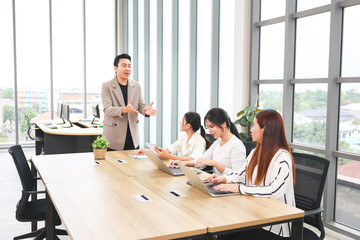Professional Business Team Collaborating in Modern Office Meeting, Businessman Leading Discussion with Female Colleagues in Conference Room