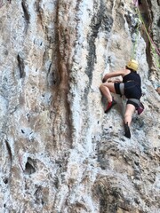 climber on the top Female athlete top rope rock climbing at Railay Beach, Ao Nang, Krabi Province,...