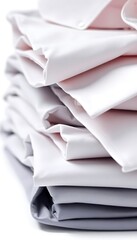 stack of folded white sheets on a white surface
