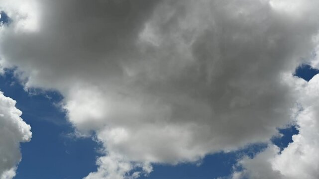 Bright Blue Sky with Fluffy White Clouds and Sunlight Peeking Through