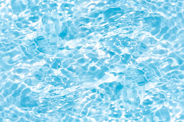 Fototapeta premium Blue water with ripples on the surface. Defocus blurred transparent blue colored clear calm water surface texture with splashes and bubbles. Water waves with shining pattern texture background.