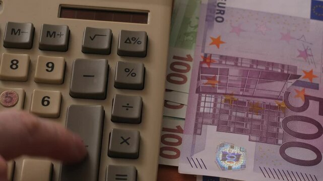 Close-up calculator and euro banknotes of different denominations, concept income and expense calculation, budget planning