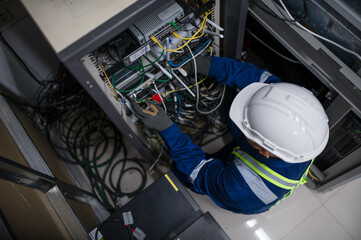 Server expert repair technicians are checking the integrity of server cabinet cable connections to...
