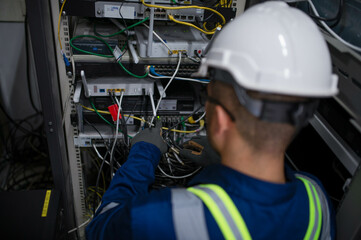 Fototapeta premium Server expert repair technicians are checking the integrity of server cabinet cable connections to ensure proper and efficient internet operation.