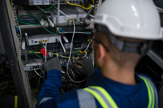 Server expert repair technicians are checking the integrity of server cabinet cable connections to ensure proper and efficient internet operation.