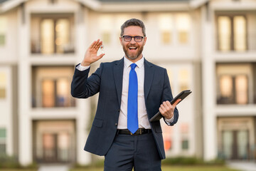 Realtor key in suburb neighborhood. Man purchasing house for investment purpose. Property insurance services. Ownership. American settlement agent. Real estate agent sell property. Good deal