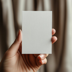 A hand holding a white card with a pattern on it. The card is blank and has no writing on it