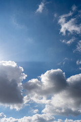 Soft white clouds float across a clear blue sky on a sunny day. A peaceful, minimal composition capturing the calm beauty of a fair weather afternoon.