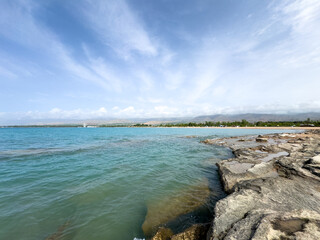 Rocky shore and clear water of Issyk-Kul under a vast sky