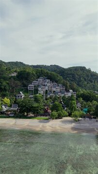 Explore stunning aerial views of Phuket Island, featuring clear waters, lush limestone hills, and captivating landscapes, highlighting Thailands vibrant tropical paradise and its enchanting beauty