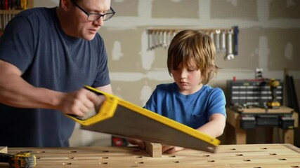 Father and Son Bonding at Wooden Workbench with Tools in Garage under Warm Lighting