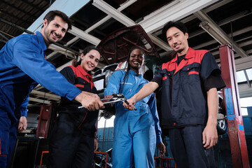 Harmonious professional mechanic teamwork, multiracial engineers with wrenches united, cheerful,...
