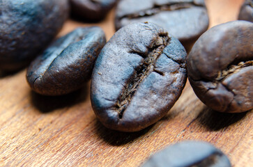 Close up view roasted coffee beans that highlights the texture and surface details of the coffee beans with customizable space for text