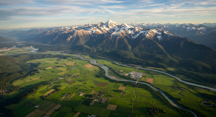 Scenic Aerial View of Snow-Capped Mountains and Lush Green Fields with River Flowing