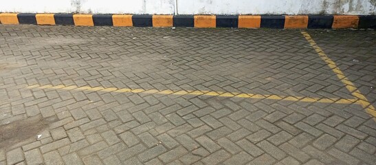 Empty Parking Area with Herringbone Pavers and Striped Curb