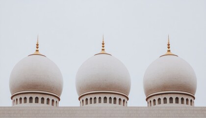 Three white domes against a pale sky