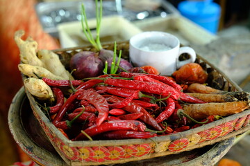 Red Chili Pepper, Ginger, Onion, and Salt in Mug on Woven Wooden Tray