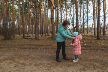 Grandmother and granddaughter walking in the forest