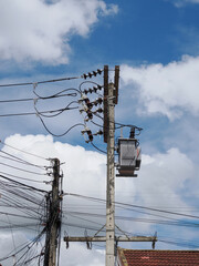Electrical pole against hazy blue sky with power lines