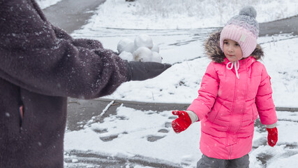 Grandmother with grandchildren in warm clothes playing outdoors in winter park, enjoying snowy...