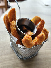 Crispy banana with chocolate jam, has a crunchy texture, sweet and savory taste. Served attractively in a nature-themed cafe.
