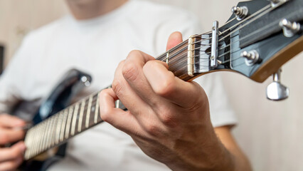 Guitar music. The performer plays. Practice chords. Male performer hands with fingers studying...