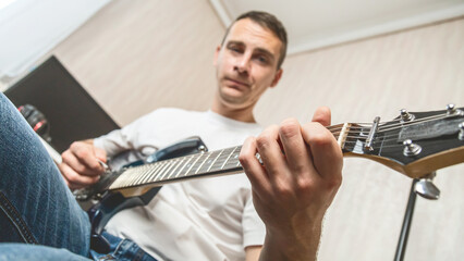 Musician, guitarist or man studying at home for performance practice, hobby or solo track with...