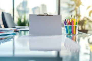 A white clipboard sits on a desk with a glass of colorful pens