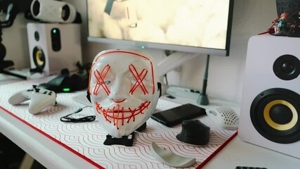 Close-up of expressive mask on stylish workspace. Idea of hidden identity, digital lifestyle, and streaming culture. Great for content about cyber world, for gamers, streamers and online persona.