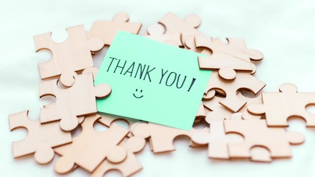 A visual representation of appreciation featuring a thank you note amidst scattered puzzle pieces.