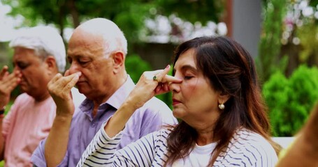 Indian senior friends doing Pranayama or pranayam together outdoors, Asian elderly people practicing breathing exercise in garden setting, seated with closed eyes, focused on mindful yoga, wellness - Powered by Adobe