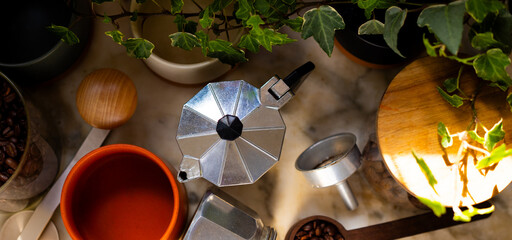 Moka coffee maker and coffee making accessories on the kitchen table.