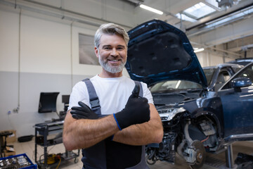 Mechanic holding gloves in workshop