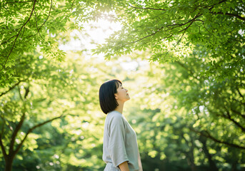 自然の空気や木々の香りで癒されている女性