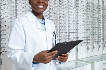 Female african american optician in a lab coat looking contented and positive