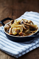 Onion with mushrooms. Rustic wooden background.	