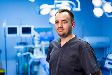 Surgeon in modern operating room setting. Surgeon wearing scrubs stands confidently in a high-tech...