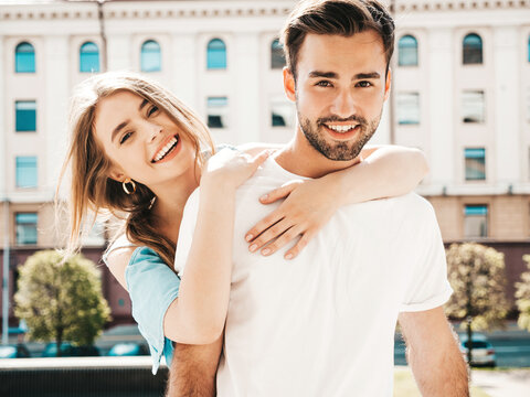 Fototapeta Portrait of smiling beautiful woman and her handsome boyfriend. Woman in casual summer jeans dress. Happy cheerful family. Female having fun. Couple posing on the street background