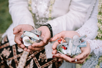 Happy Couple Showing Coins and Bills in Hand at Traditional Javanese Wedding