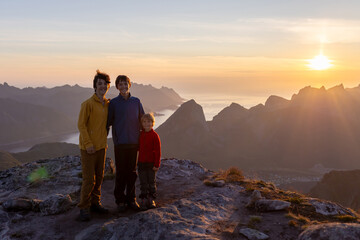 Fototapeta premium Children and adults, family with dog, hiking Grytetippen trail in Senja, Lofoten on a sunny hot summer day