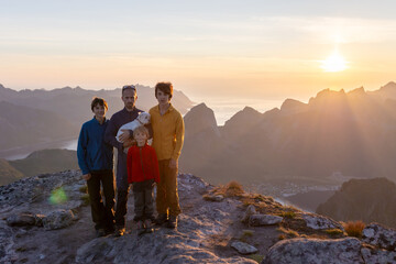 Naklejka premium Children and adults, family with dog, hiking Grytetippen trail in Senja, Lofoten on a sunny hot summer day