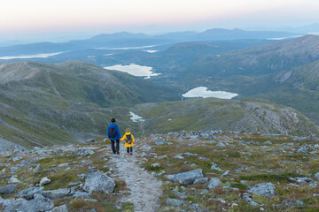 Fototapeta premium Children and adults, family with dog, hiking Grytetippen trail in Senja, Lofoten on a sunny hot summer day