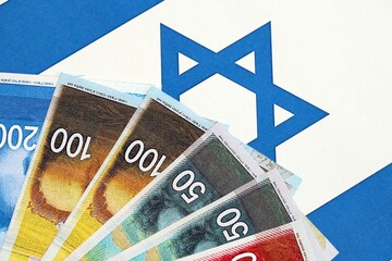 Israel New Shekels banknotes on national flag. The current Israel money bills lies on flag