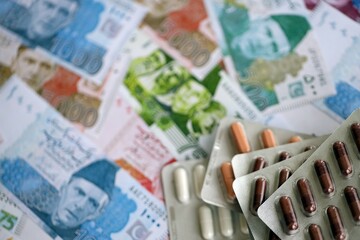 Pakistan rupees banknotes and medicine pills. Pakistan money bills with drugs close up